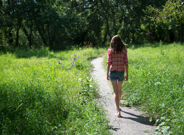 Girl walking on summer path