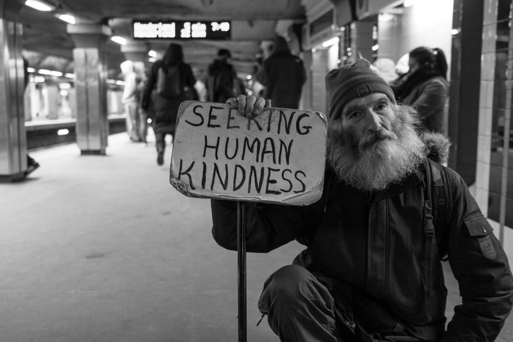 Seeking Human Kindness, homme avec pancarte en noir et blanc