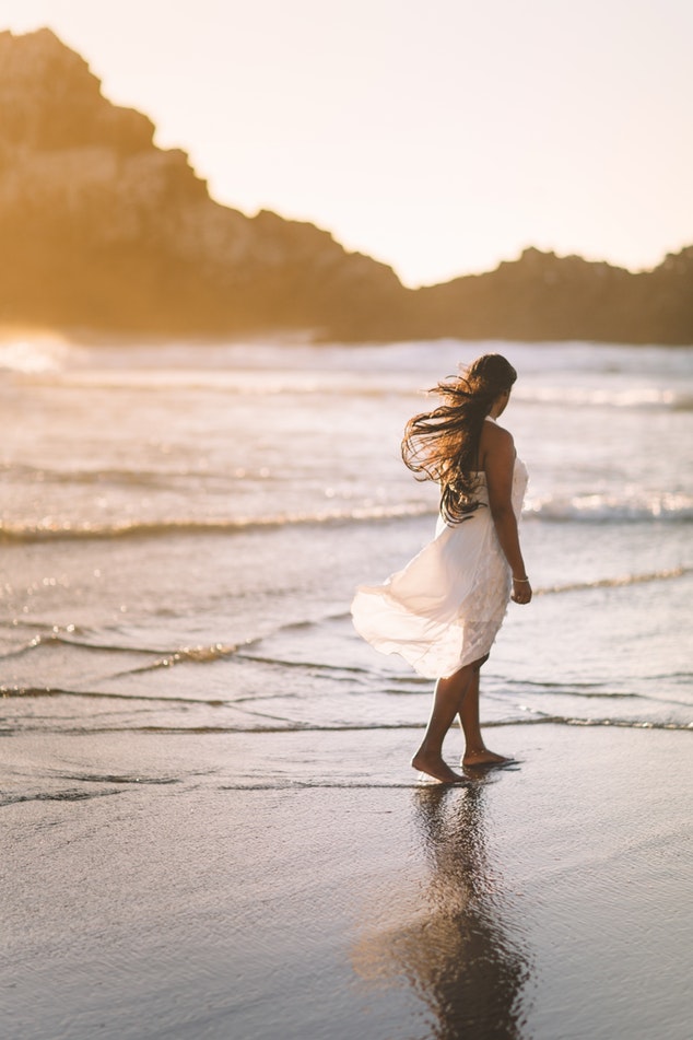 femme sur la plage avec robe blanche au vent 