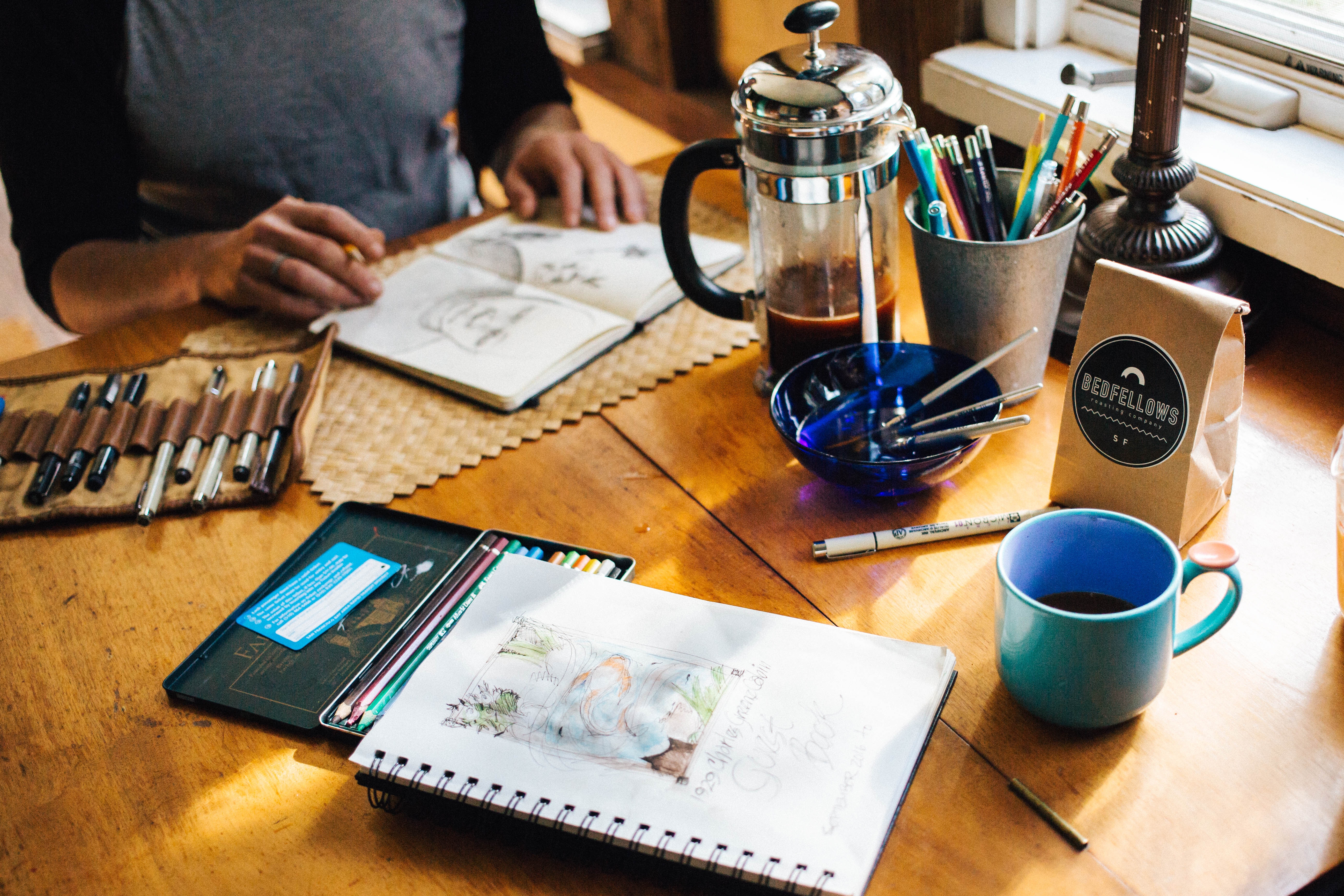cahier de dessin, pinceaux, table à café, tasse à café