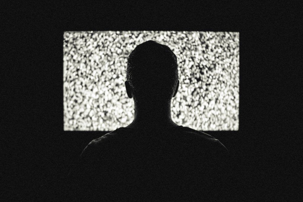 homme devant la télé qui «griche», noir et blanc