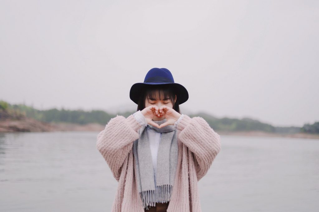 fille chapeau coeur avec les mains