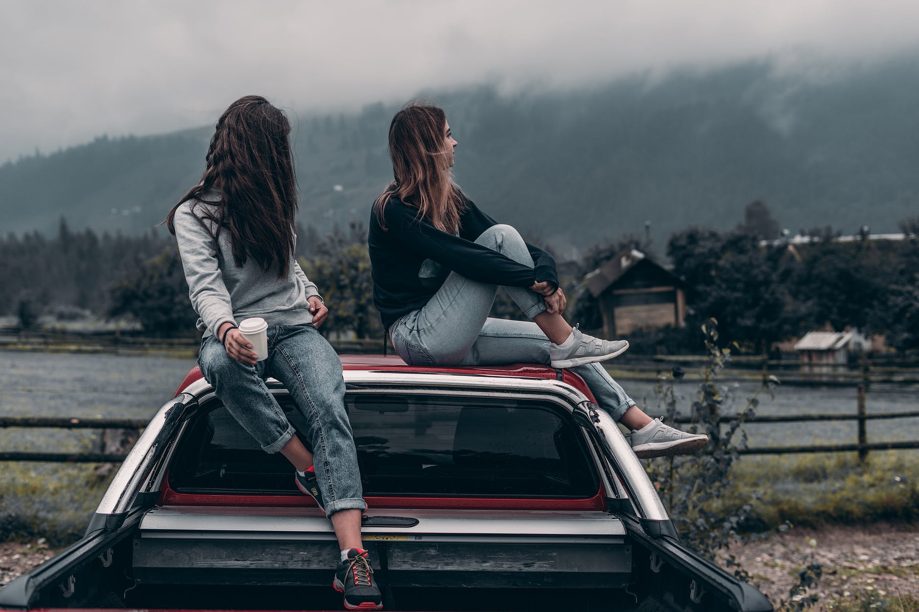 Deux amies sur le toit d'un pick-up dans les montagnes