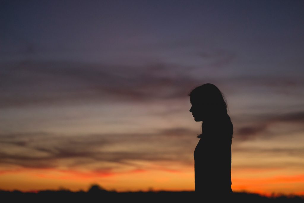 silhouette femme seule devant coucher de soleil