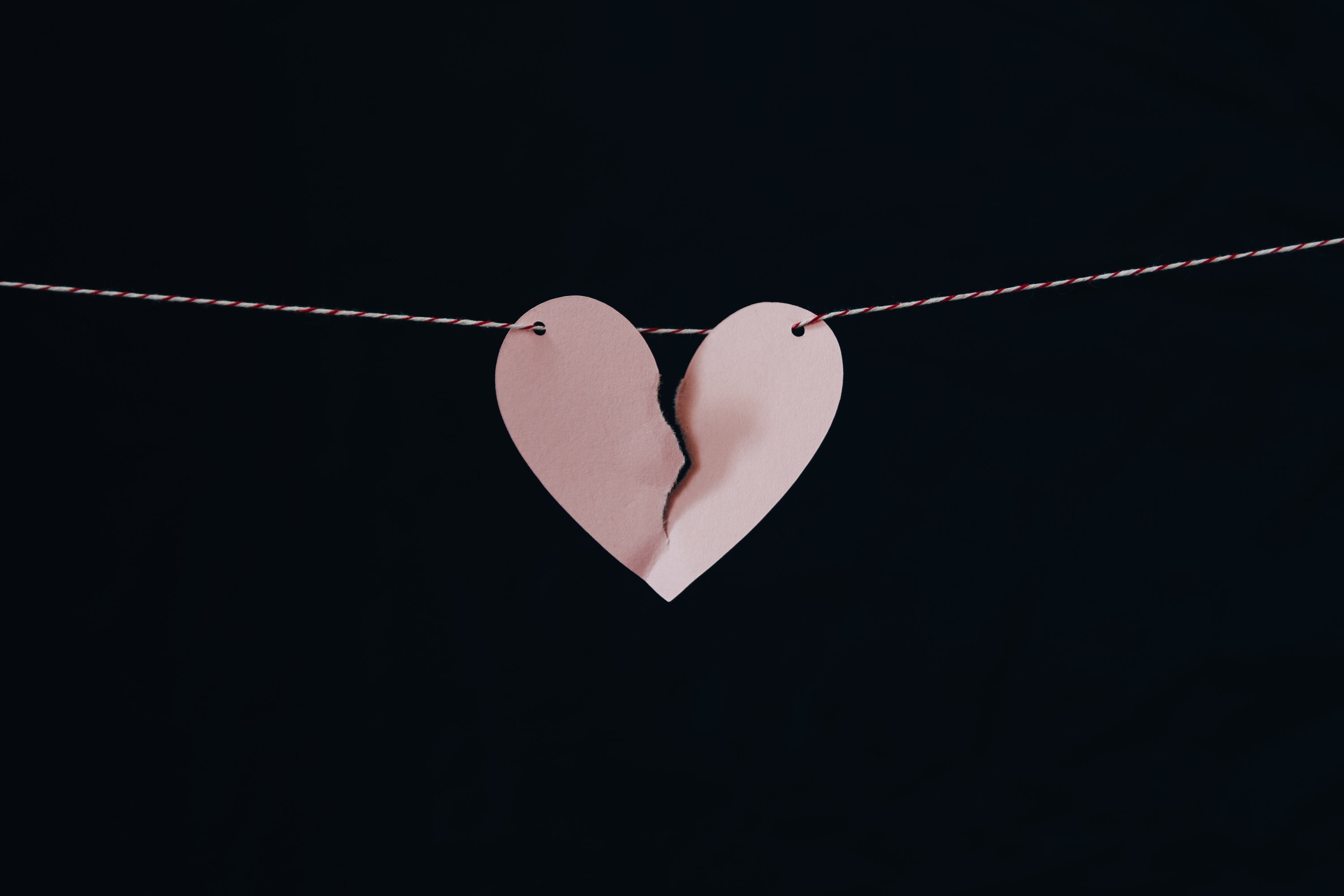 coeur brisé rose accroché sur une corde