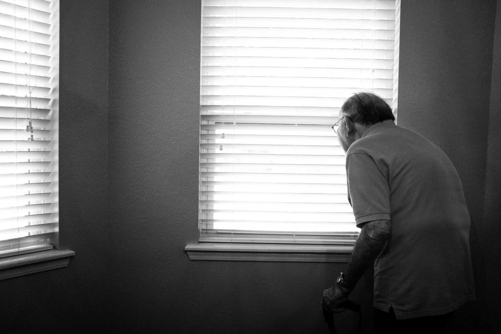 personne âgée devant une fenêtre