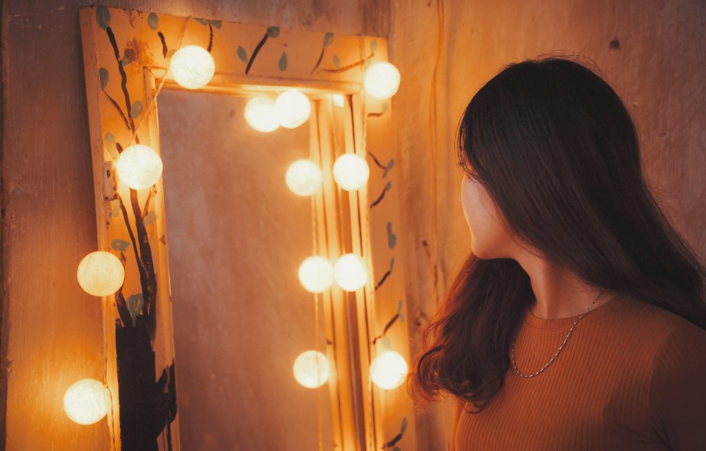 fille qui se regarde dans un miroir avec lumières