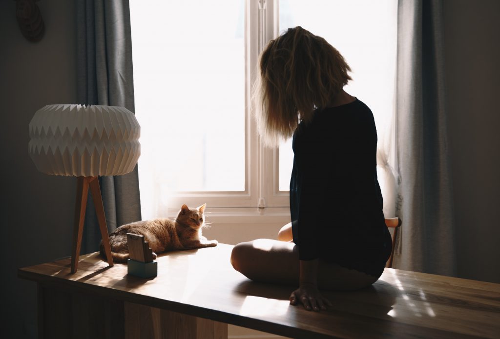 femme assise sur une table avec chat