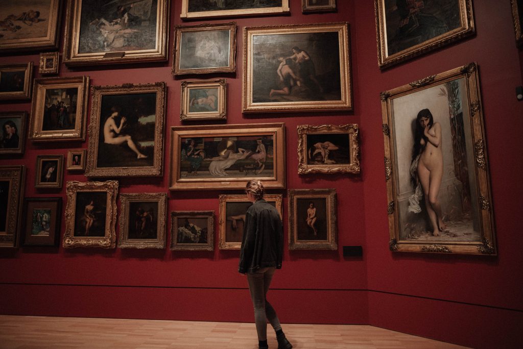 femme au milieu de toiles dans un musée