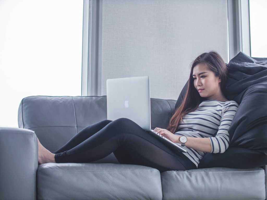 femme étendue sur divan avec ordinateur portable