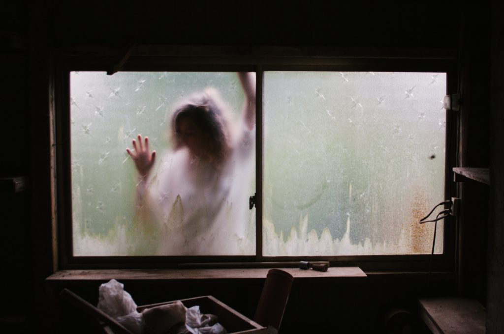 femme derrière une fenêtre embuée