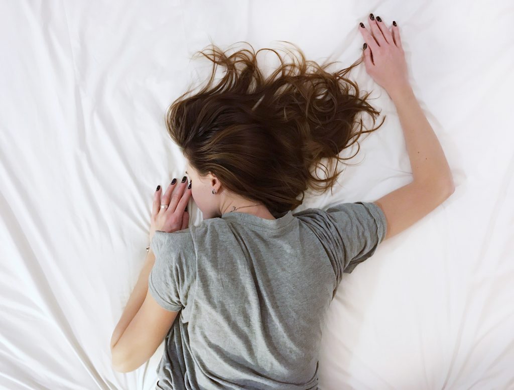 femme couchée sur le ventre lit cheveux éparpillés