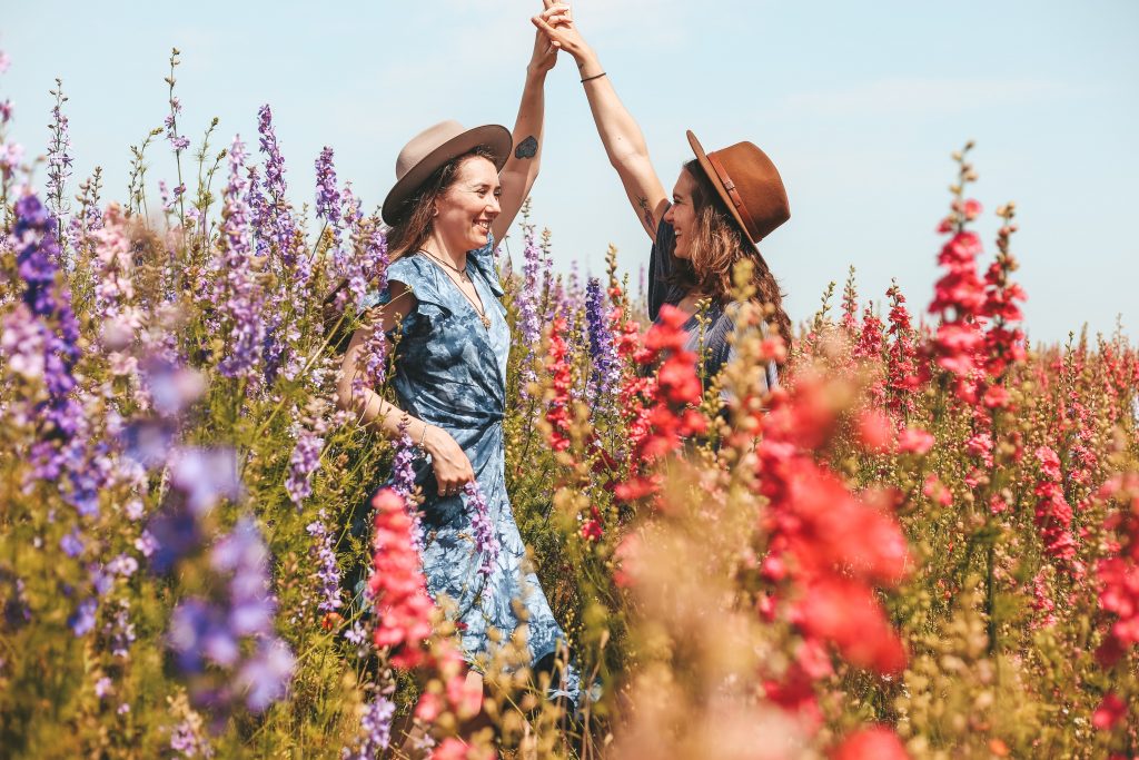 femmes main dans la main champ de fleurs
