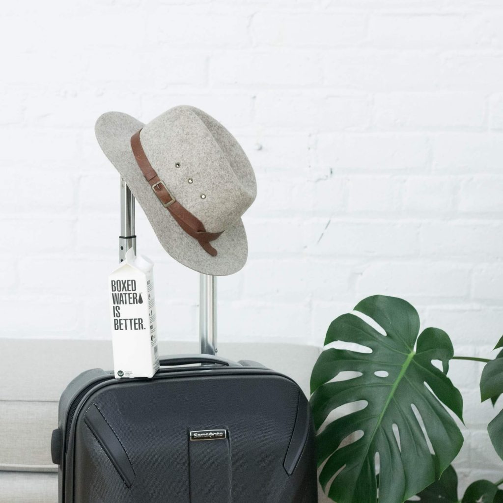valise, chapeau et bouteille d'eau en carton