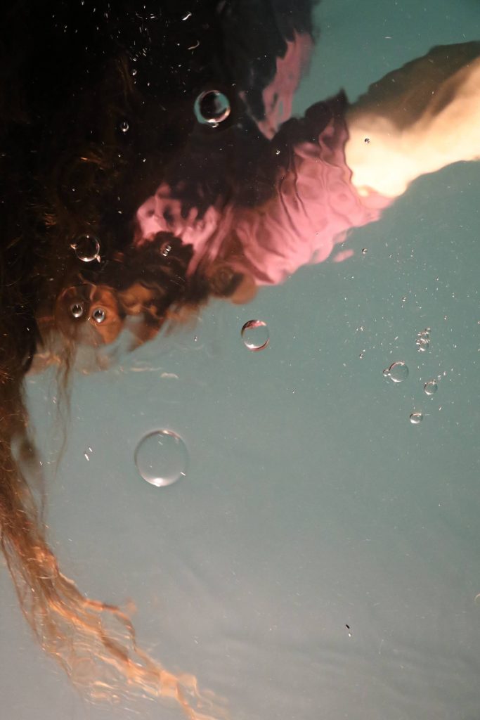 reflet sur l'eau d'une personne avec des bulles