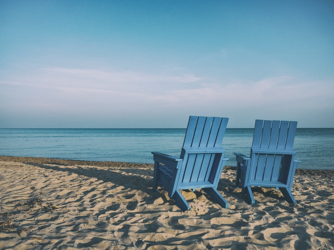 Deux chaises de plage bleues près d'un plan d'eau