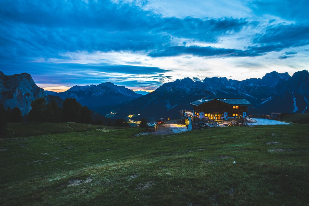 Chalet près des montagnes sous le ciel bleu au coucher du soleil