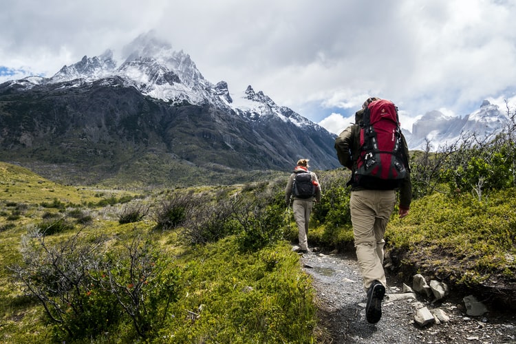 Deux personnes marchant vers une montagne