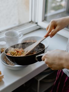 personne qui cuisine dans une poêle