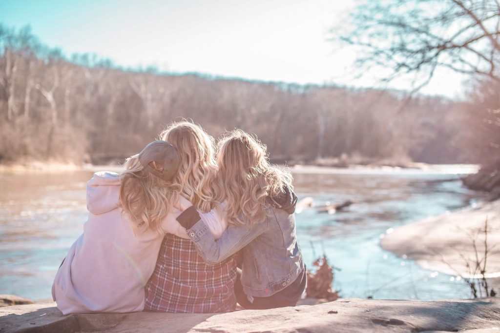 3 filles qui se collent devant un lac